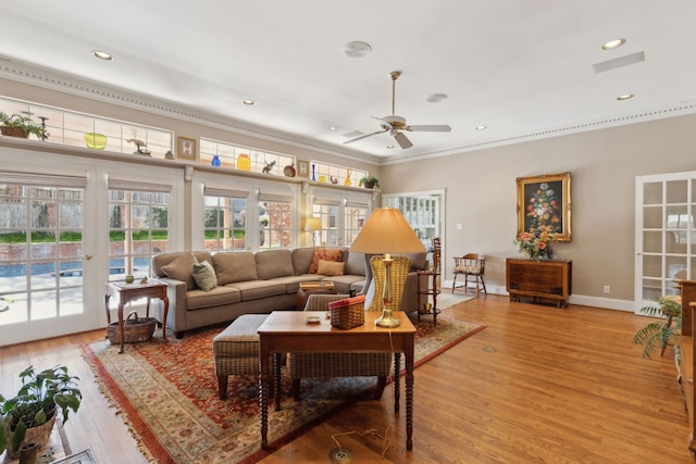 living area with a ceiling fan, baseboards, french doors, light wood finished floors, and crown molding