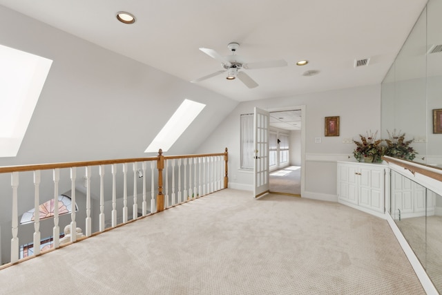 bonus room featuring ceiling fan, vaulted ceiling with skylight, recessed lighting, and light colored carpet