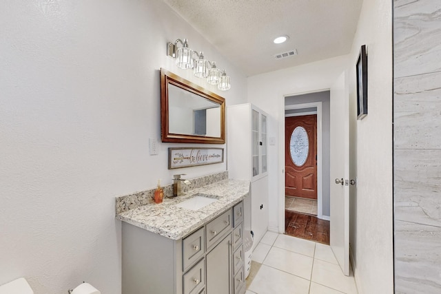 bathroom featuring visible vents, a textured ceiling, vanity, and tile patterned flooring