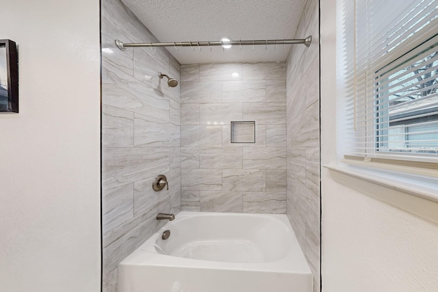 bathroom featuring a textured ceiling and washtub / shower combination