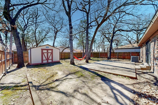 view of yard featuring an outbuilding, cooling unit, a shed, a fenced backyard, and a patio area