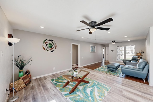 living room with recessed lighting, baseboards, and wood finished floors