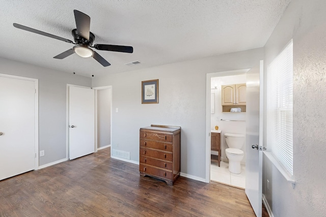 bedroom with visible vents, a textured ceiling, and wood finished floors