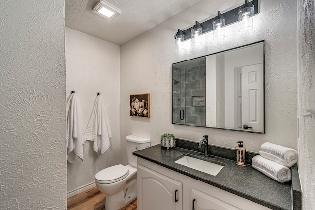 bathroom with a textured wall, a stall shower, and a textured ceiling