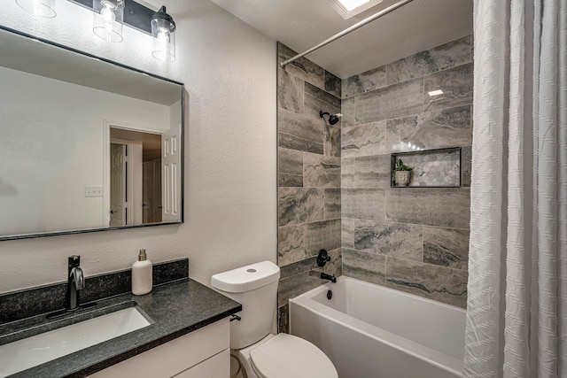 bathroom with vanity, toilet, shower / tub combo, and a textured wall