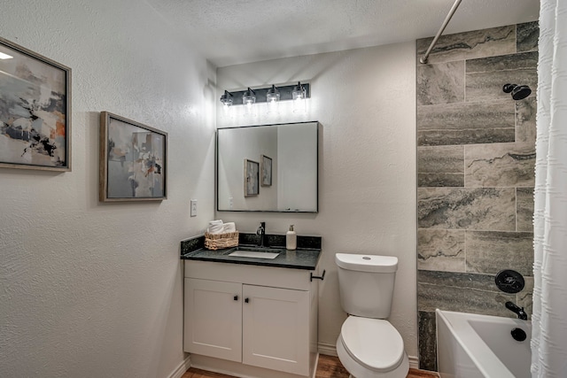 bathroom featuring toilet, a textured ceiling, vanity, and a textured wall