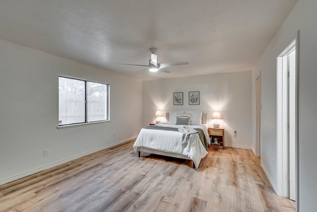 bedroom with baseboards, a ceiling fan, and light wood finished floors