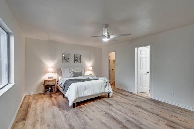 bedroom featuring baseboards, light wood-style floors, and a ceiling fan