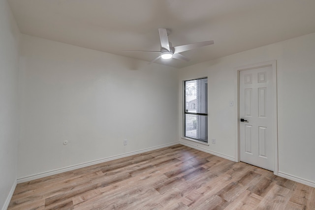 spare room featuring baseboards, light wood-style flooring, and a ceiling fan