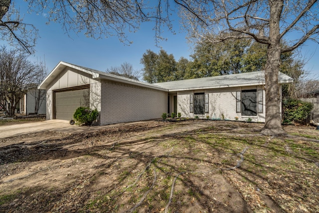 mid-century home featuring an attached garage, brick siding, board and batten siding, and driveway