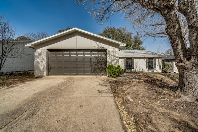 mid-century inspired home featuring brick siding, driveway, and a garage