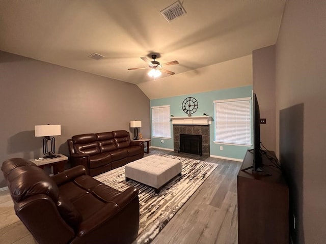 living area featuring vaulted ceiling, ceiling fan, visible vents, and baseboards