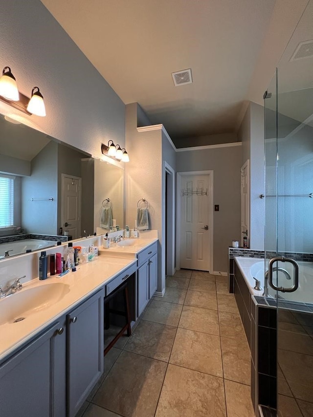 bathroom with double vanity, visible vents, a garden tub, tile patterned flooring, and a sink