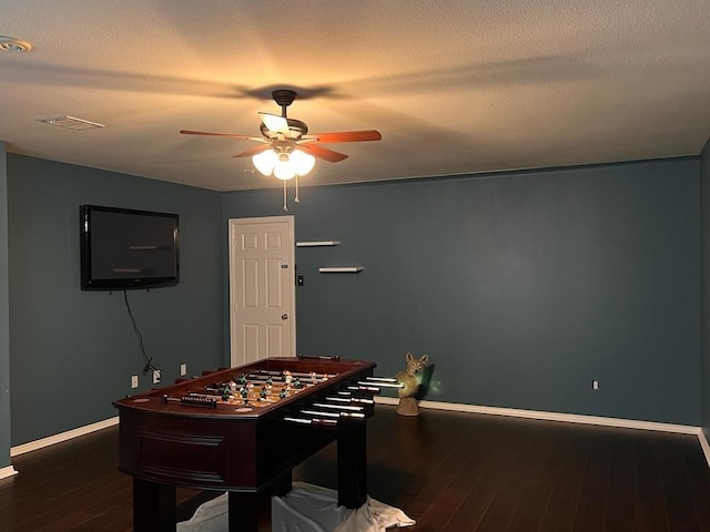 playroom with a ceiling fan, a textured ceiling, baseboards, and hardwood / wood-style flooring