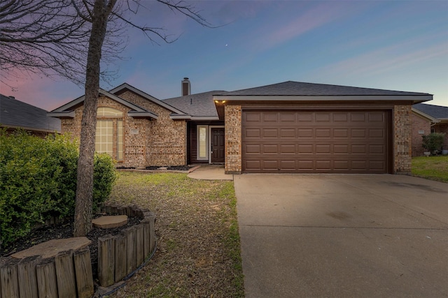 single story home featuring brick siding, a chimney, concrete driveway, and a garage