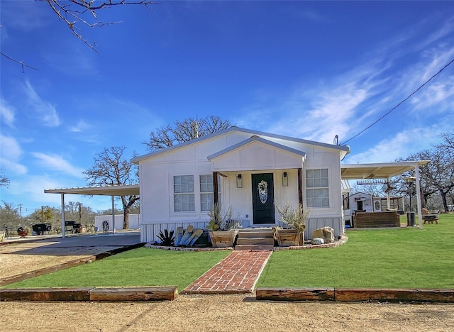 view of front of home featuring driveway, a carport, and a front yard