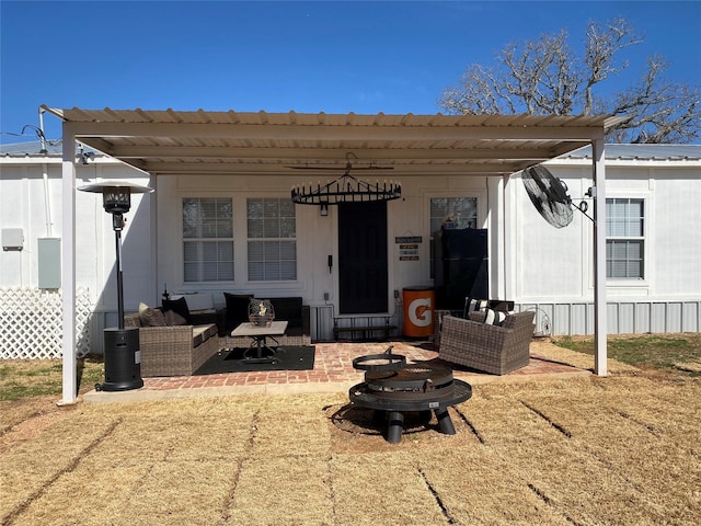 rear view of property with metal roof, an outdoor living space, and a patio