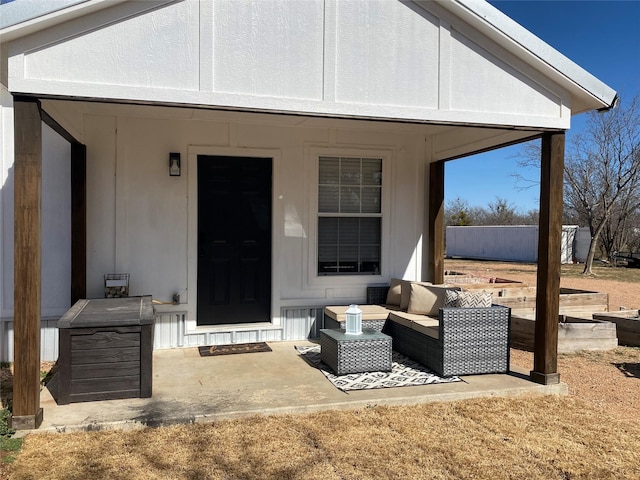 entrance to property with a patio area and an outdoor living space