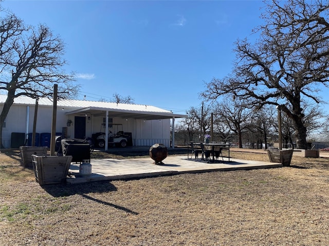 view of yard featuring an attached carport and a patio area