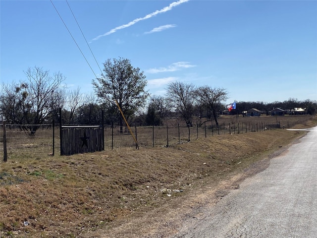 view of yard with a rural view and fence