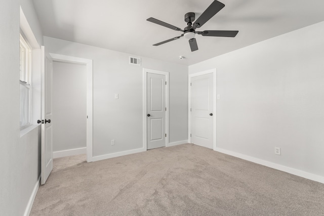 unfurnished bedroom with baseboards, visible vents, ceiling fan, and carpet flooring