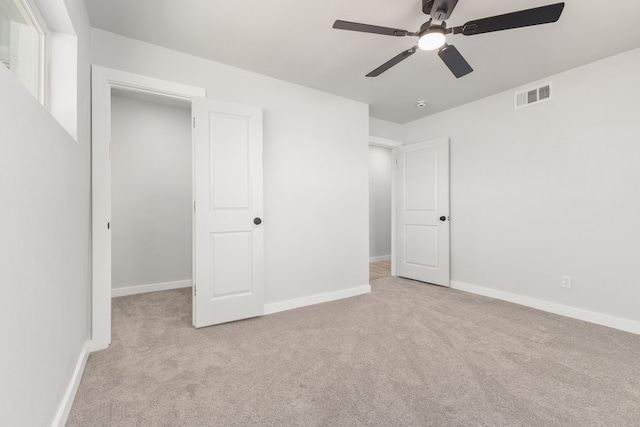 unfurnished bedroom featuring carpet floors, visible vents, baseboards, and a ceiling fan