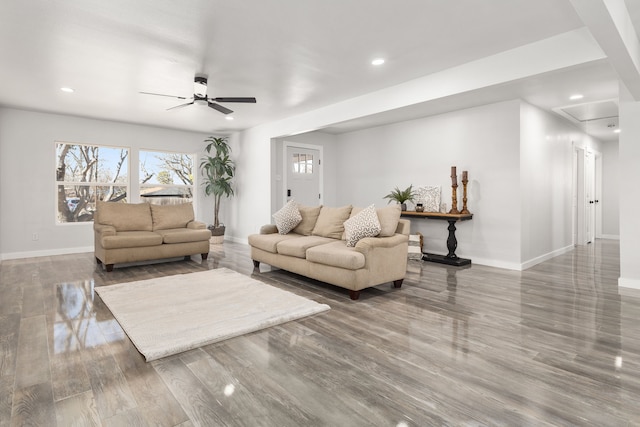 living room featuring ceiling fan, baseboards, and wood finished floors