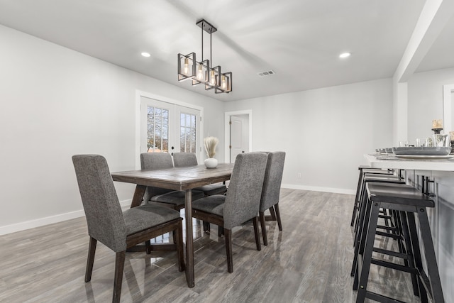 dining area with baseboards, visible vents, wood finished floors, and french doors