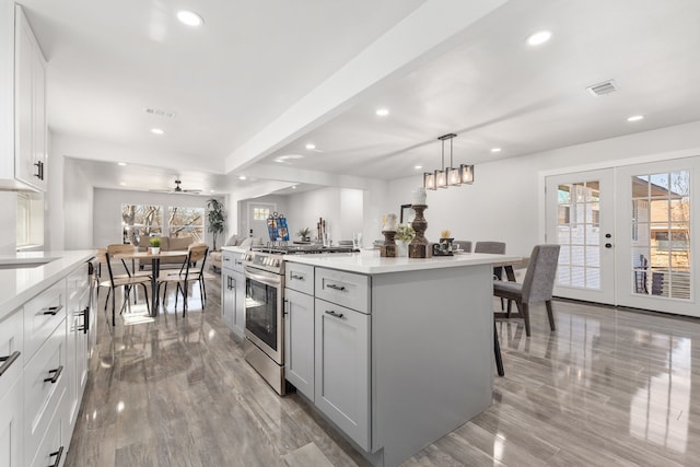 kitchen with stainless steel range with gas cooktop, french doors, visible vents, and recessed lighting