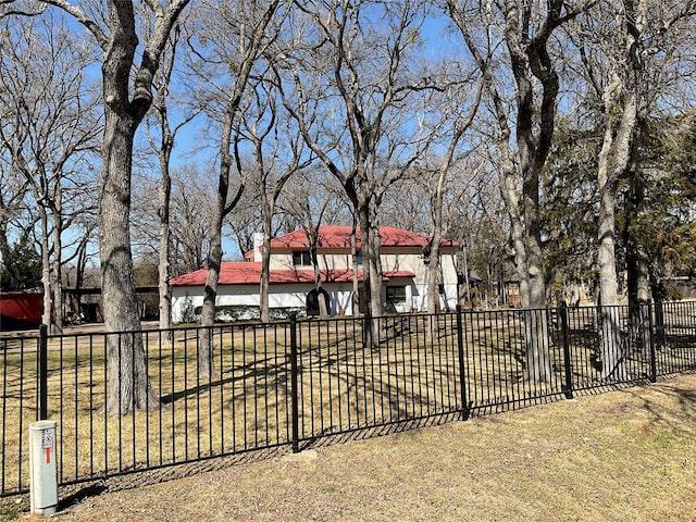 view of front of property featuring a tiled roof, fence, and stucco siding