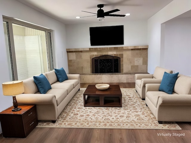 living room with ceiling fan, a fireplace, and wood finished floors