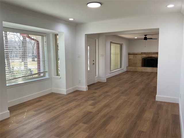 entrance foyer with ceiling fan, recessed lighting, wood finished floors, baseboards, and a tiled fireplace