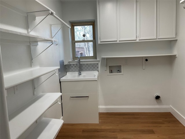 laundry area with washer hookup, cabinet space, a sink, and wood finished floors