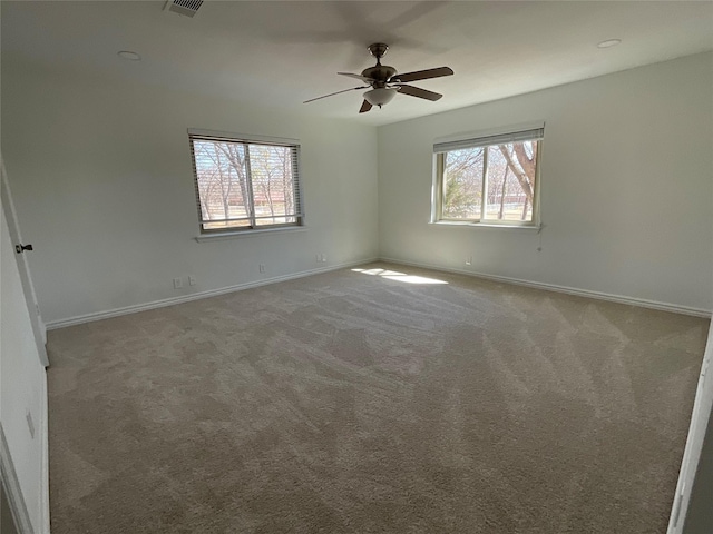 spare room with visible vents, carpet, a ceiling fan, and baseboards