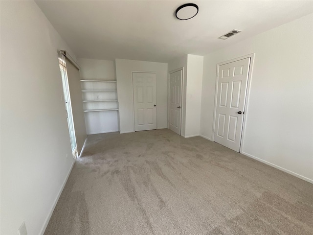 empty room with baseboards, visible vents, and carpet flooring