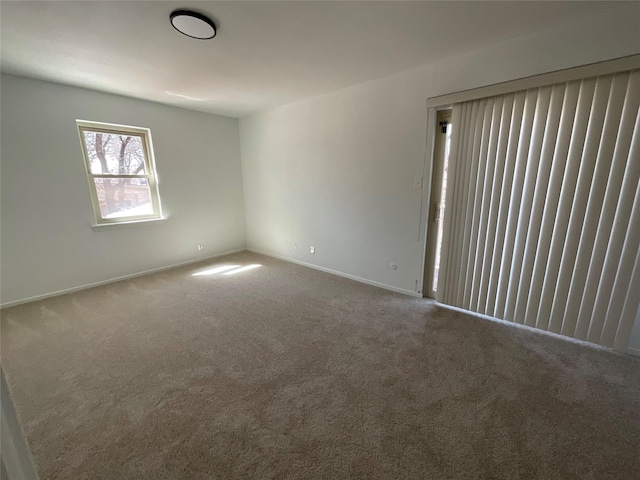 empty room featuring carpet and baseboards