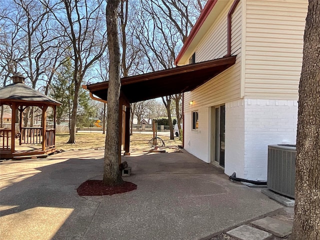 view of patio / terrace with central AC, driveway, and a gazebo