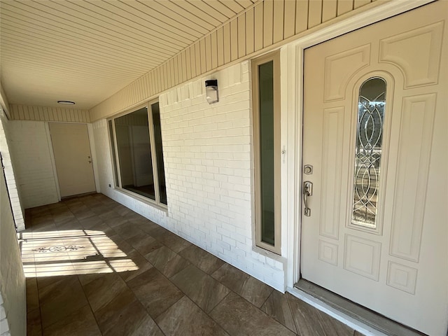 entrance to property featuring brick siding