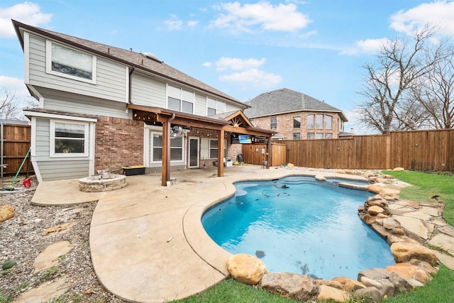 rear view of house featuring brick siding, a fenced backyard, a pool with connected hot tub, and a patio