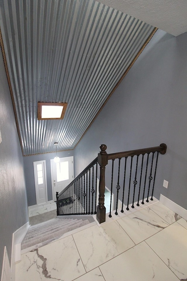 stairs featuring marble finish floor and baseboards