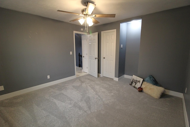 unfurnished bedroom featuring a ceiling fan, light colored carpet, and baseboards