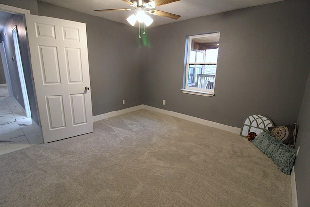 unfurnished bedroom with baseboards, a ceiling fan, and light colored carpet