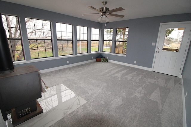 unfurnished sunroom featuring ceiling fan