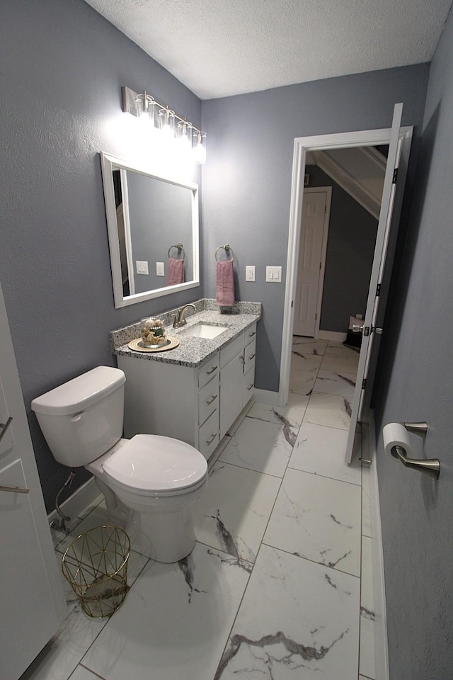 bathroom featuring baseboards, toilet, marble finish floor, a textured ceiling, and vanity