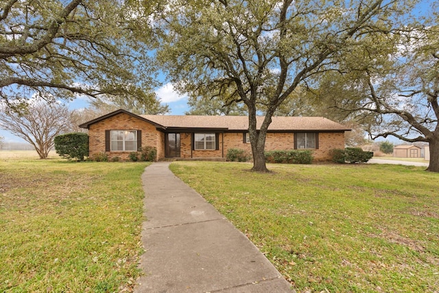 ranch-style home featuring brick siding and a front yard