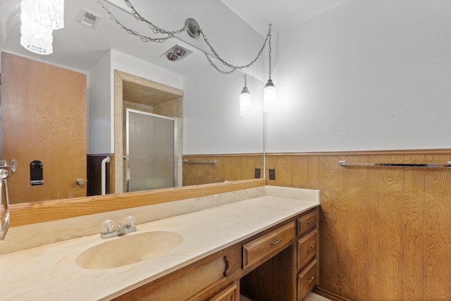 full bath featuring visible vents, wainscoting, vanity, wood walls, and a shower stall