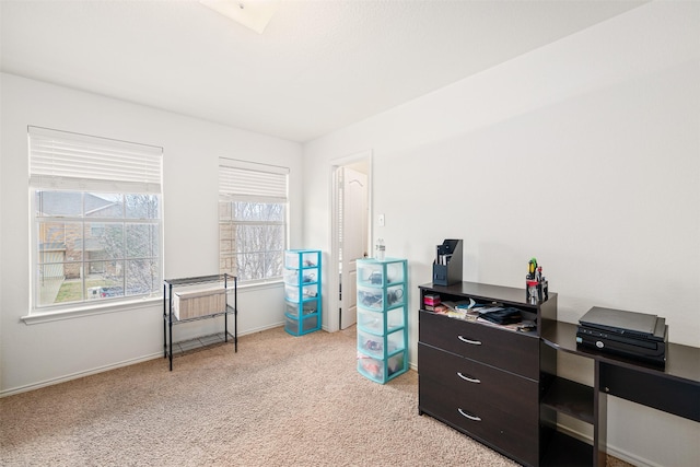 office space featuring light carpet and baseboards