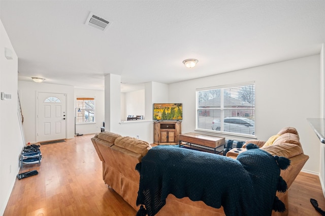 living area with light wood-style flooring and visible vents