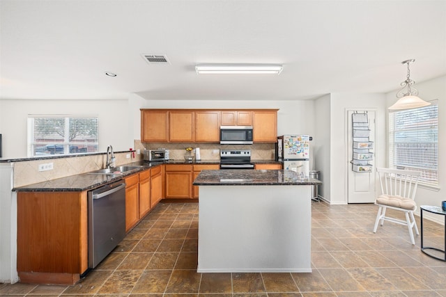 kitchen with stainless steel appliances, a sink, visible vents, backsplash, and plenty of natural light