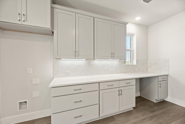 kitchen with tasteful backsplash, baseboards, dark wood finished floors, and light countertops